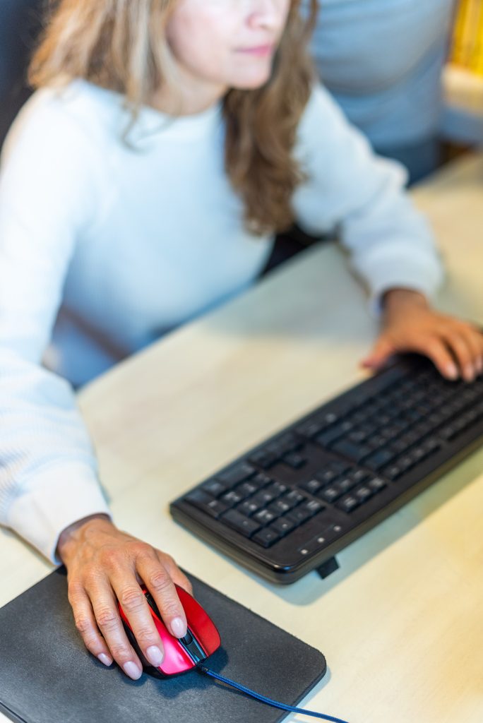 Detail of unrecognizable woman working in front of the computer