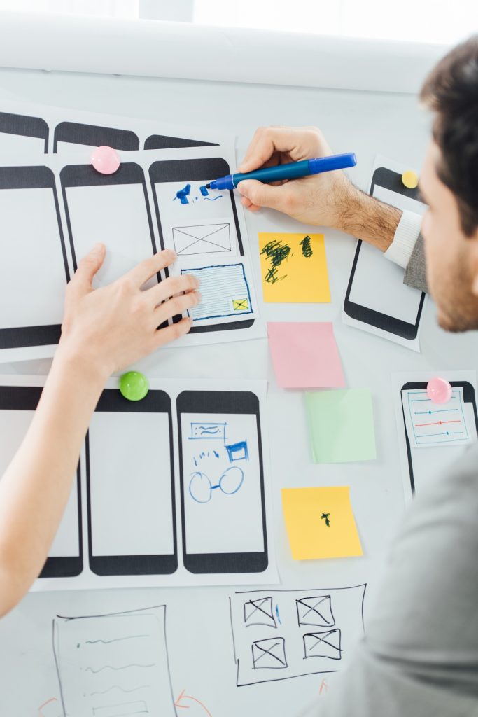 Selective focus of designers planning user experience design of mobile website on whiteboard