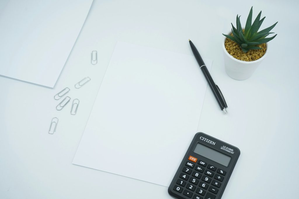 Calculator and pen on paper for planning a website budget